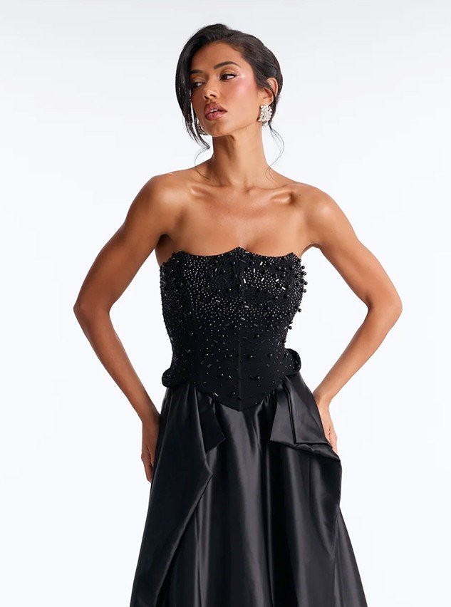 Model in a strapless beaded black satin gown